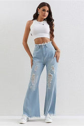 Verwaschene blaue Jeans mit Rissen, Patchwork-Details und offenem Saum, schmaler Passform und ausgestelltem Bein