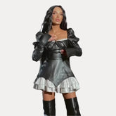 Schwarzes Lederkleid mit tiefem Ausschnitt und Schnürung sowie Rüschen