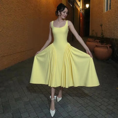 Gelbes, schmal geschnittenes, plissiertes Ballkleid mit quadratischem Kragen und Hosenträgern